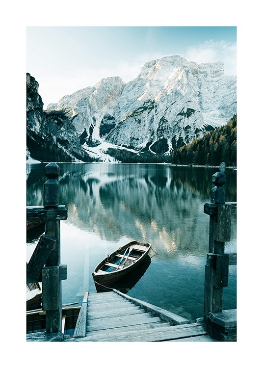  – Fotografie zasněžených hor za jezerem s loďkou a dřevěnými schody v popředí